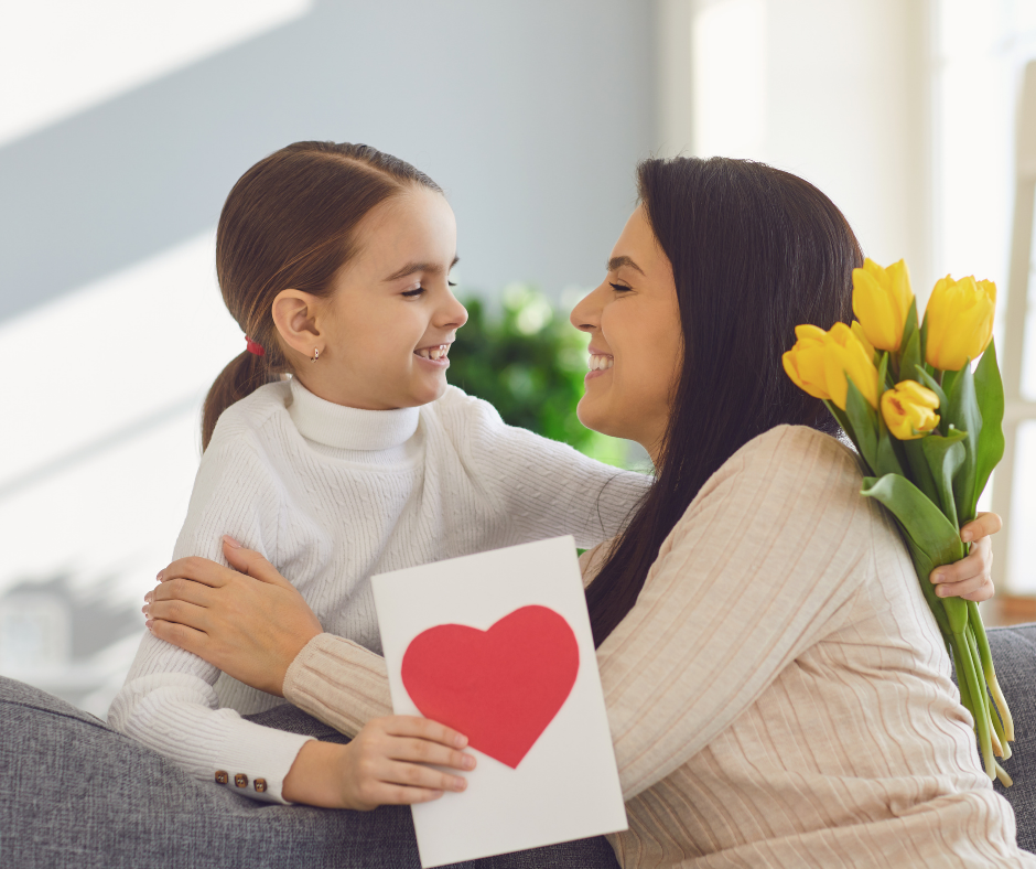 enfant qui offre une carte avec un coeur à sa maman pour la fête des mères